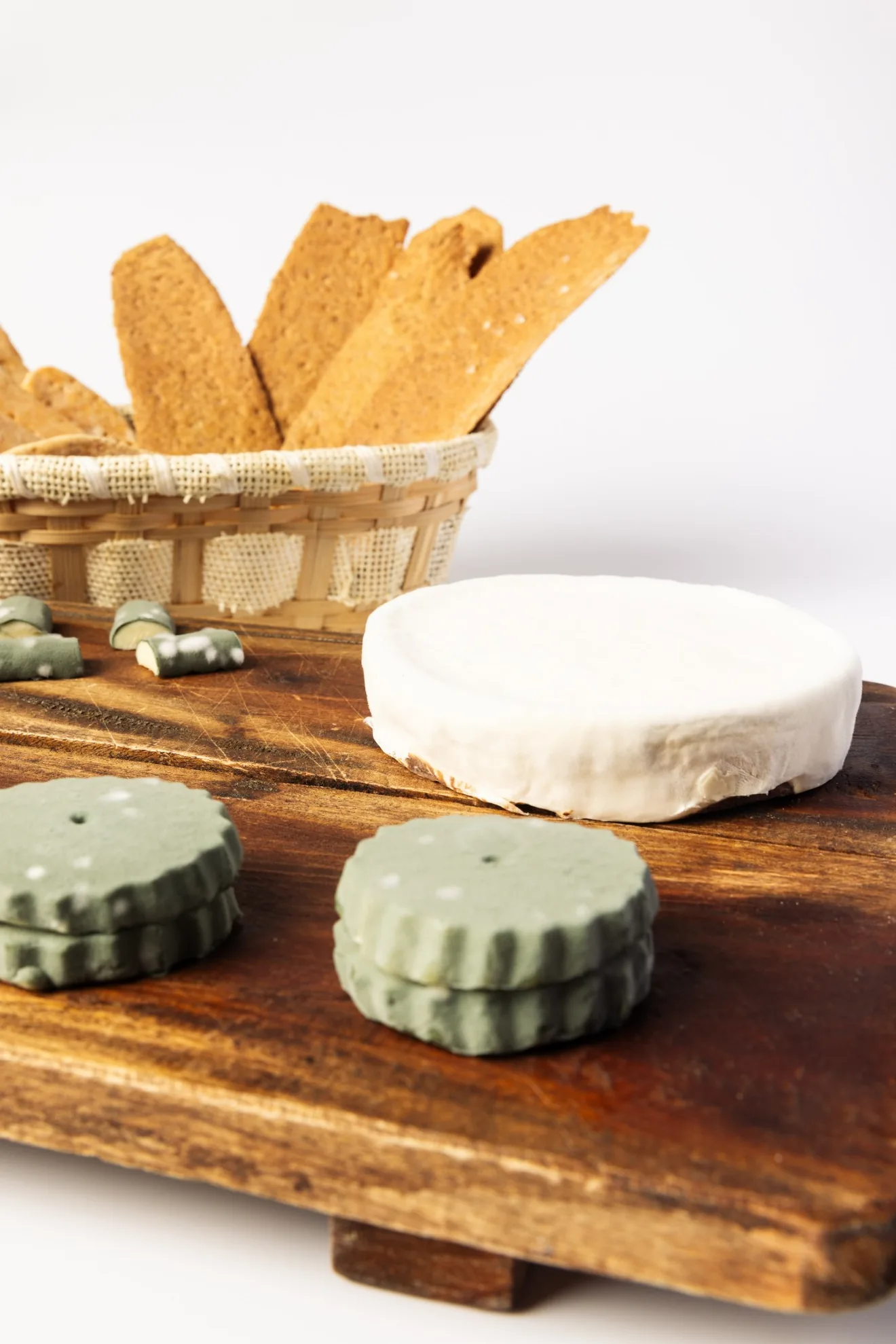 Cheese board with the brie-style cake and green biscuits.