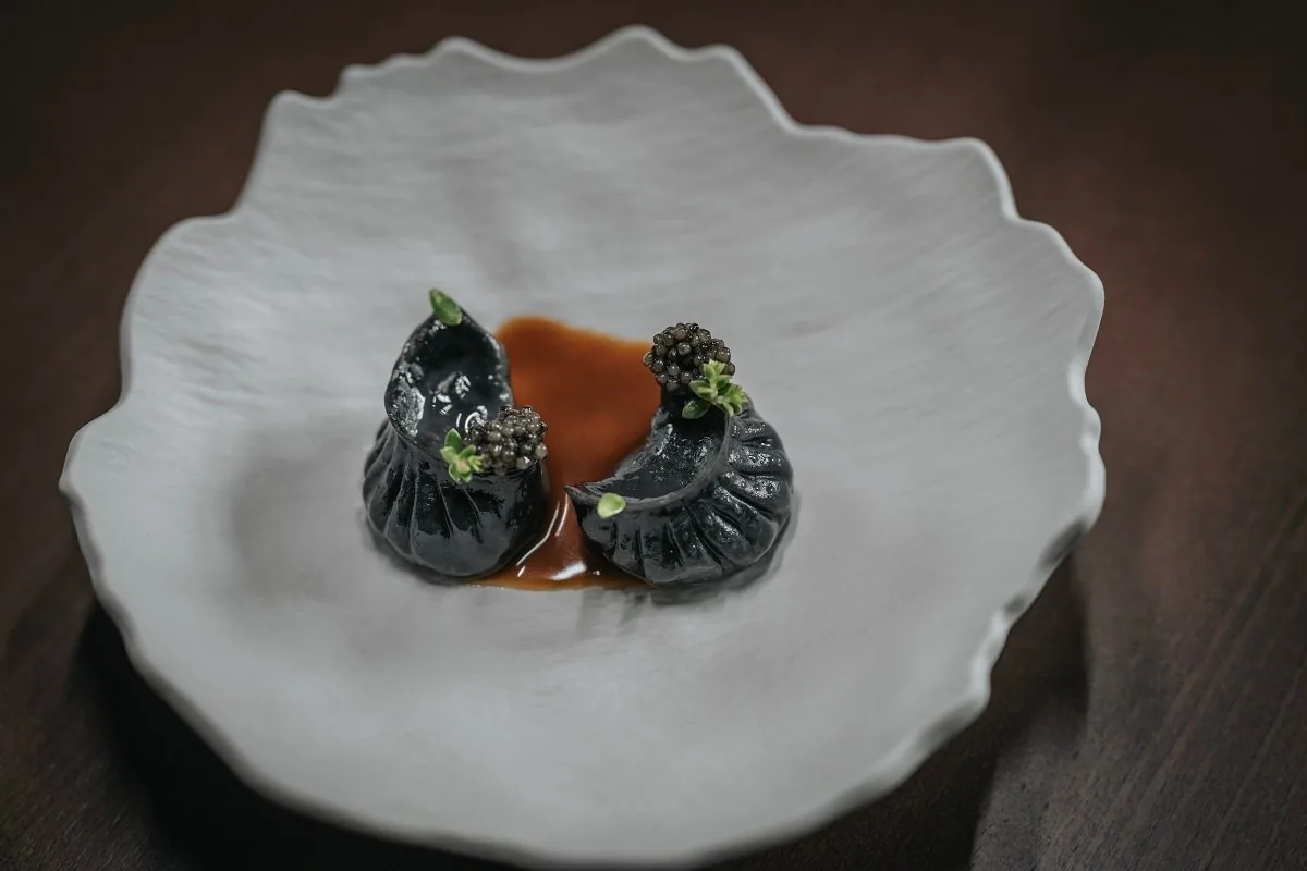 The grilled duck jiaozi on a white plate.